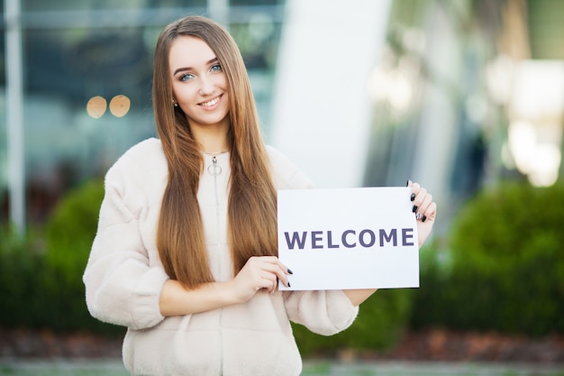 Women business with the placard with welcome message