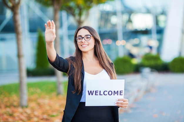 Women business with the poster with welcome message