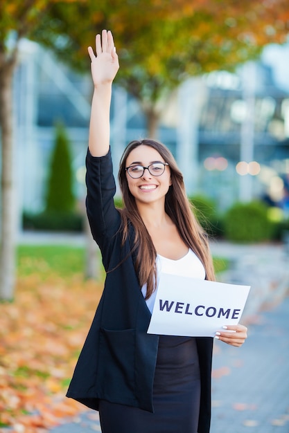 Women business with the poster with welcome message