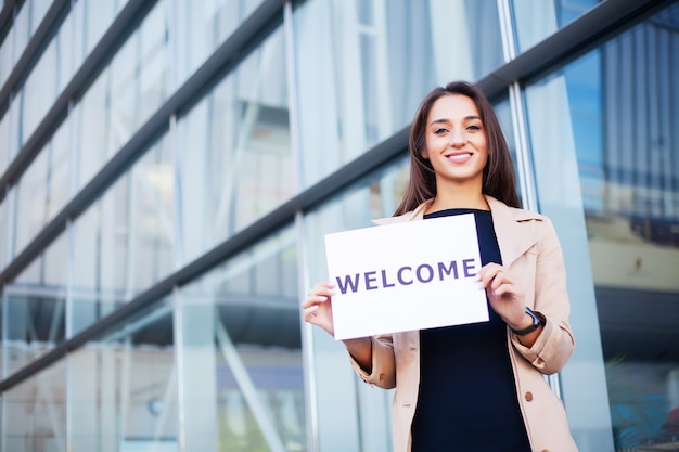 Women business with the poster with welcome message