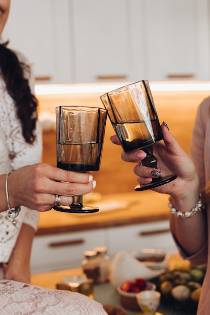 Women cheering with two black glasses