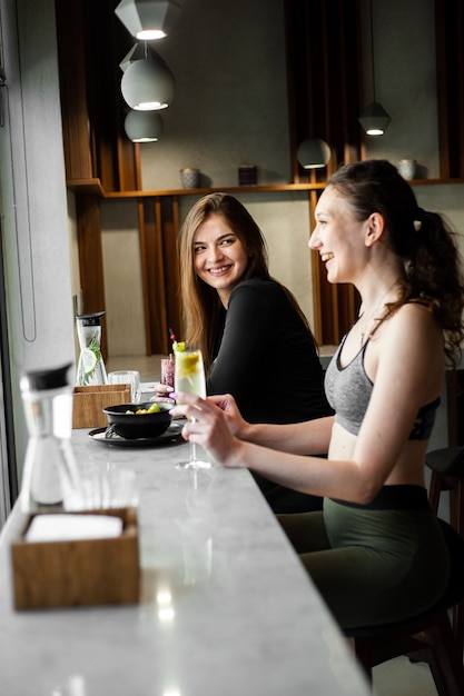 Women chiling and drink healthly drink after gym