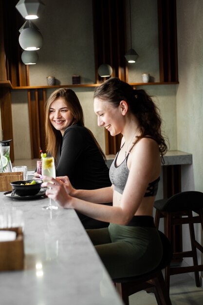 Women chiling and drink healthly drink after gym