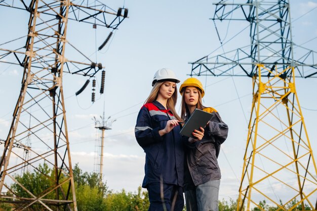 女性が機器や電力線の検査を行う