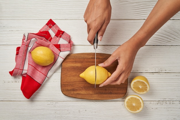 ナイフでレモンを切る女性
