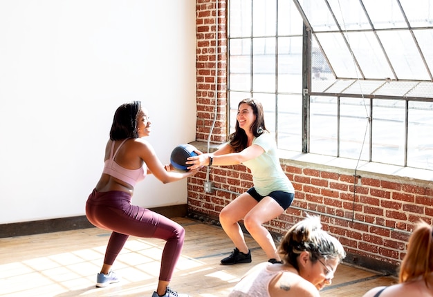 Donne che fanno squat durante la lezione di fitness