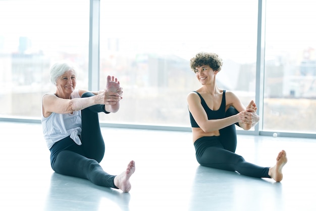 Women doing yoga next to a large window