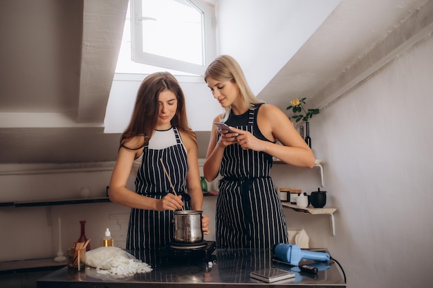 women dressed in aprons make a candle