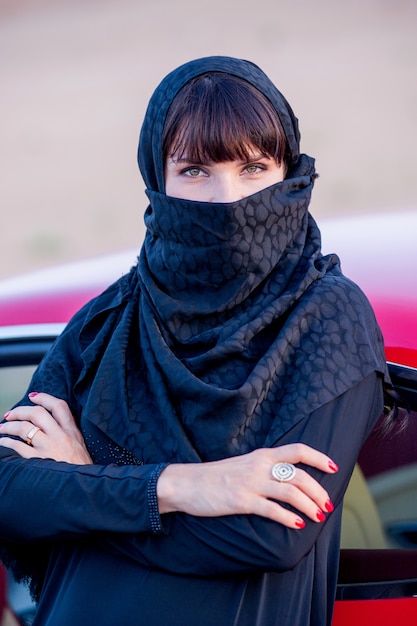 Women dressed middle eastern way poses on sunset background.