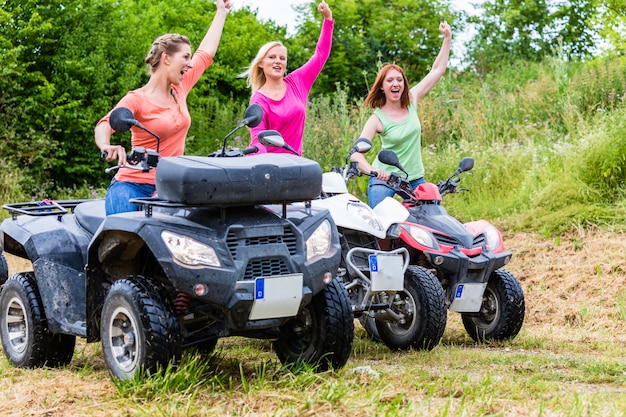 Women driving off-road with quad bike or ATV