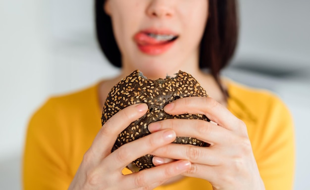 A women eating a burgherClose up burgherUnhealthy food