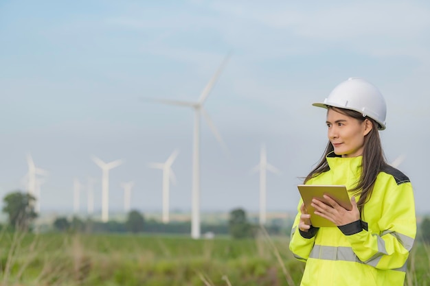 写真 mountainthailandの人々の風力タービンファーム発電機ステーションで働いてレポートを保持している女性エンジニア