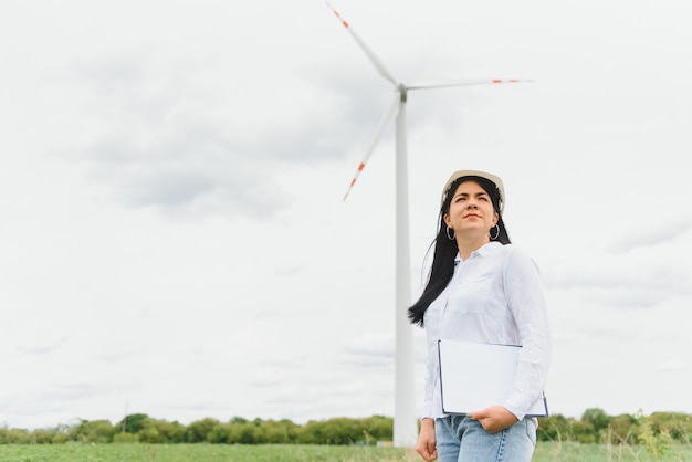 山の風力発電所発電所でレポートを保持している女性エンジニア