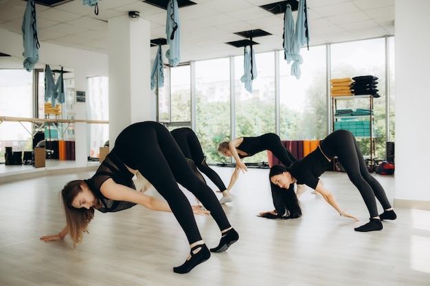 Женщины занимаются в фитнес-студии на занятиях по йоге
