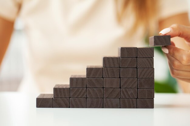 Women fingers climb up wooden block closeup