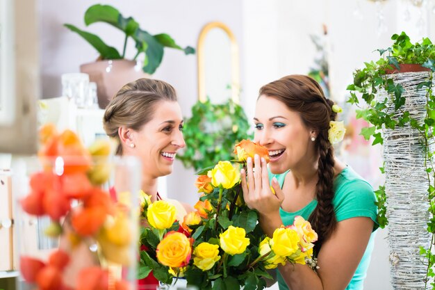 Women in flower store enjoying the roses