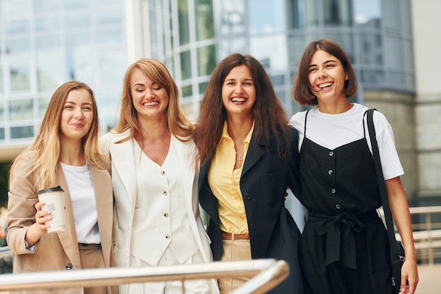 Women in formal wear is outdoors in the city together