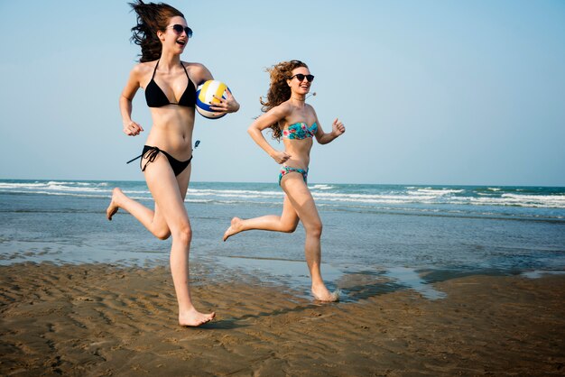 Women friendship playing volleyball beach summer concept