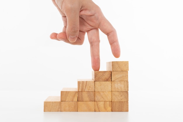 Women hand finger walk on stacked wooden block.