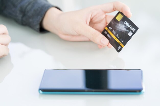 Women hand holding credit card and using cell phone for online shopping