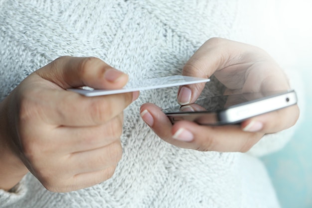 Photo women hand holding credit card and using smart phone shopping online.