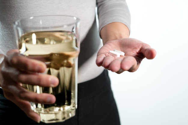 women hand holding medicine with glass of water medicine recovery concept