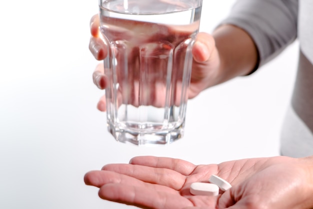 women hand holding medicine with glass of water medicine recovery concept