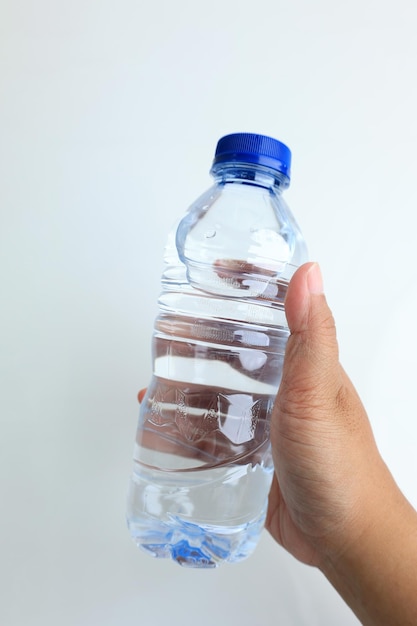 Women Hand Holding Plastic Bottle of Mineral Woter with Blue Cap Sealed