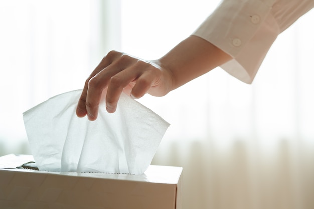 Women hand picking napkin/tissue paper from the tissue box