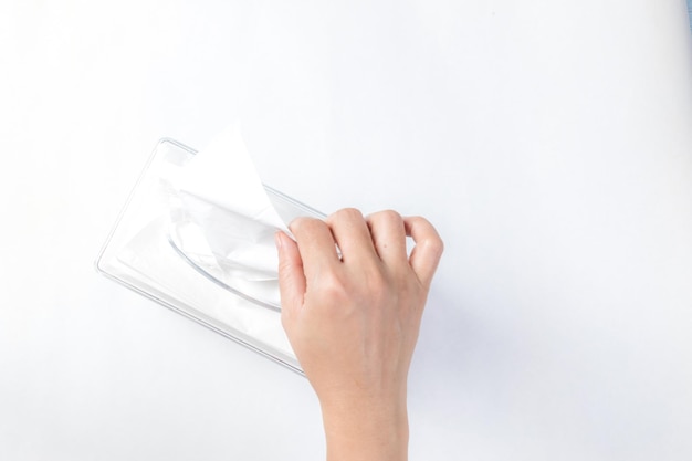 Women hand picking napkin or tissue paper from the tissue\
box