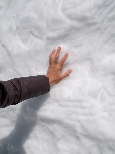 The women hand on the snow wall