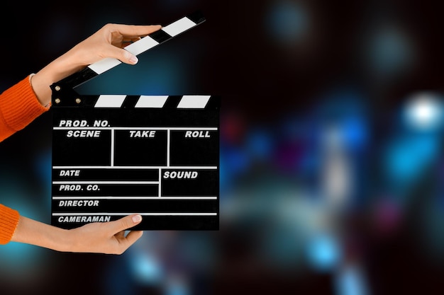 Women hands holding clapper board for making video cinema in studio.