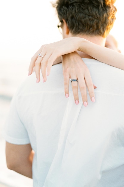 Women hands hug a man by the neck Closeup Back view