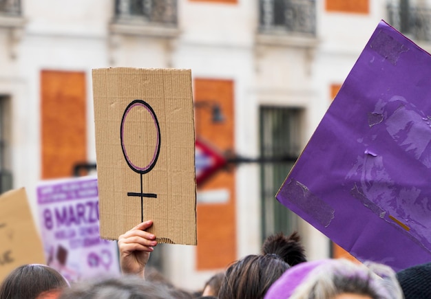 Foto le mani delle donne sostengono il cartello simbolo femminista sulla dimostrazione di 8 m