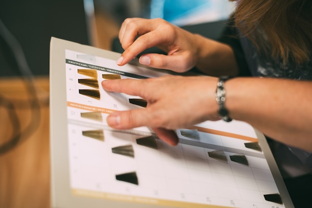 Mani da donna con un catalogo di coloranti