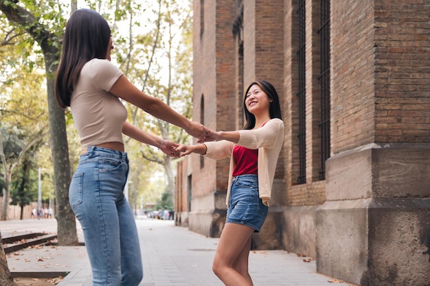 Women have a good time spinning holding hands