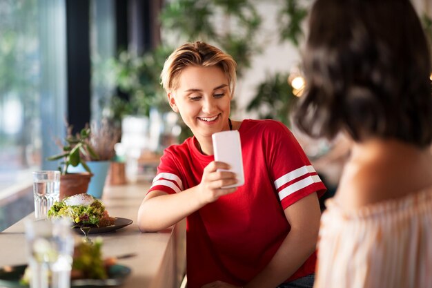 Foto donne che pranzano e fotografano al caffè