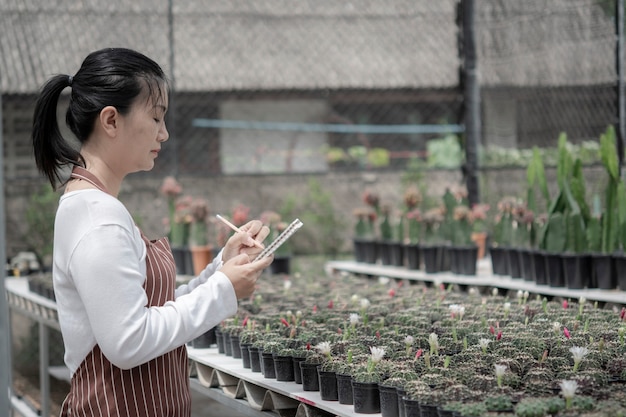 Foto le donne aiutano a prendersi cura del giardino dei cactus, il concetto di vendita online, vendere online attraverso gli alberi.