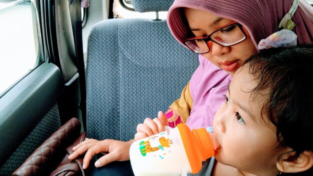 Women and her child sitting in car