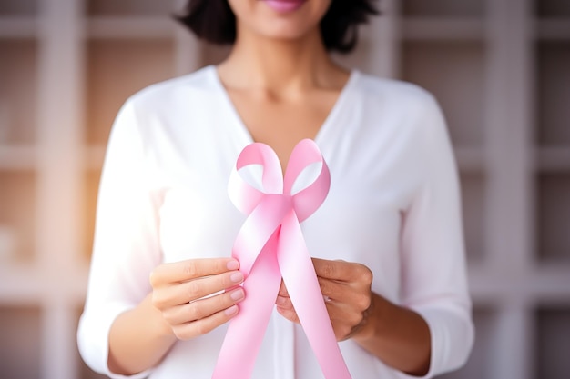 Women hold a pink ribbon in their hands the concept of fighting cancer