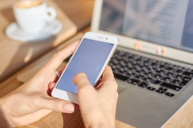 Women hold smartphone during coffee break in a cafe