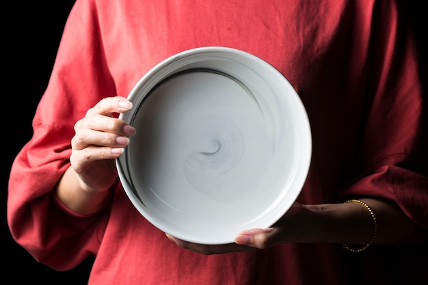 Women hold white plates in their hands.