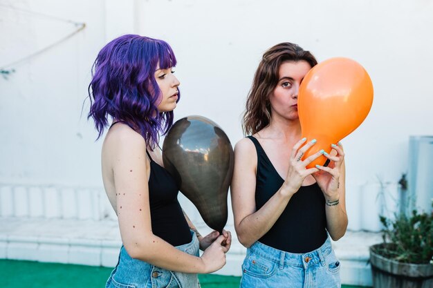 Women holding balloons while standing on land