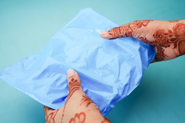 Women holding a blue color delivery packet on blue background