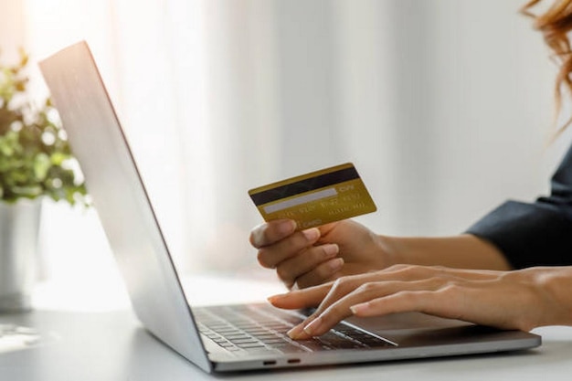 Women holding credit card and using smartphones laptop computer at homeOnline shopping internet banking store online payment spending money ecommerce payment at the store credit card concept