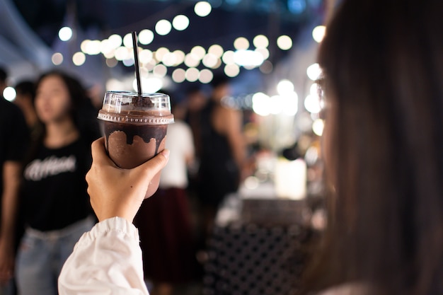 A women holding a cup of cocoa smoothie.