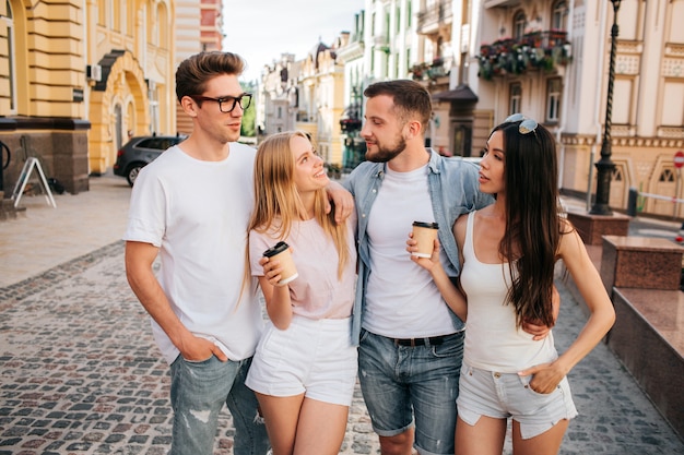 Women holding cups of coffee and looking at their boyfriends