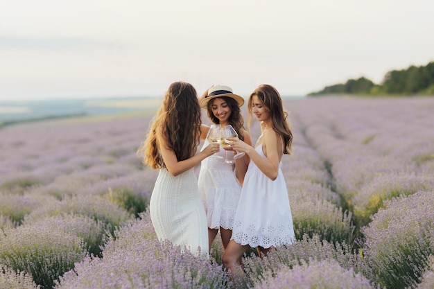 Women holding glasses of wine making a toast outdoors