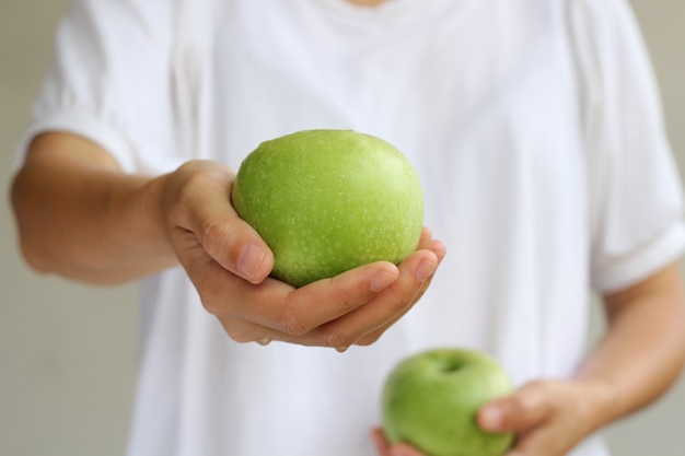 Donne che tengono mela verde