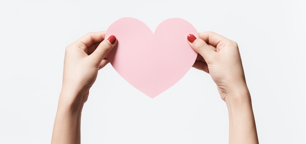 Women holding heart shape paper on white background